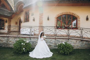 beautiful bride in tender wedding dress holding bridal bouquet in her hands