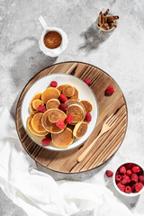 Mini pancakes with raspberries for breakfast. High key, top view