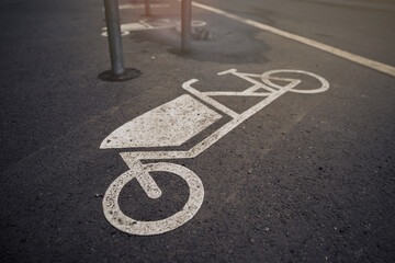 close up on cargo bike symbol on tarmac at an urban bicycle parking space in sunny bright light...