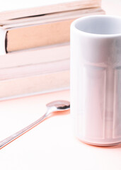 Literature concept. White books with a cup on pink background.
