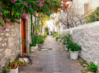 Narrow cobbled street with white and stone walls and flowers