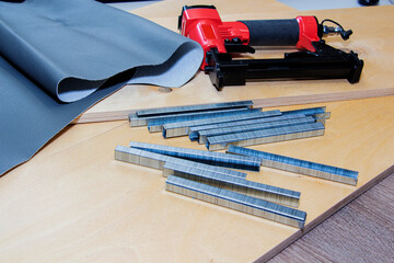 concept of furniture production and repair. Stapler and staples, working tool