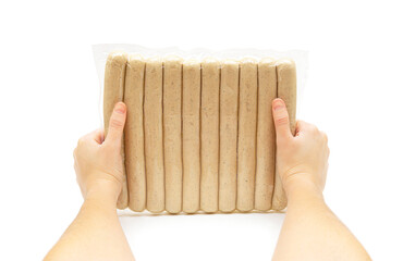 Female hands holding a pack of raw german pork sausages isolated on white