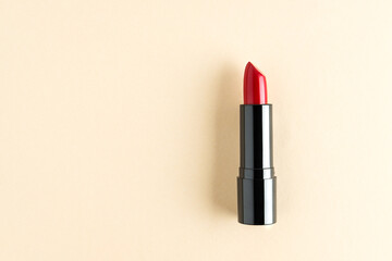 Red lipstick isolated on a cream background.