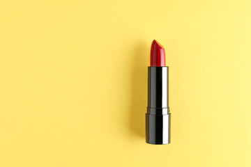 Red lipstick isolated on a yellow background.