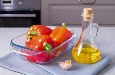 Ripe sweet red peppers are prepared for roasting in the oven with olive oil, garlic and dried...