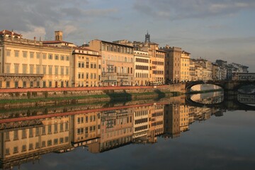 Fototapeta na wymiar Florence, Italy. Buildings under morning sun reflecting in the Arno river. 