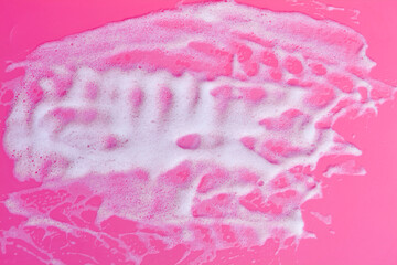 Foam bubbles and brick of soap on pink background. Cleaning service