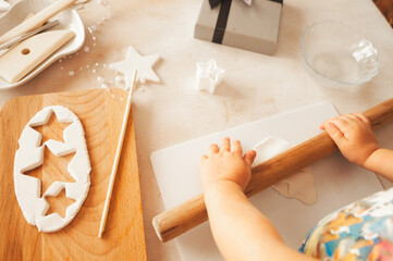 The hands of a small child who rolls out the clay to create a gift, a surprise for relatives and...