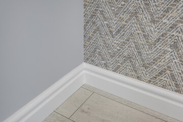 Detail of corner flooring with intricate crown molding and plinth.