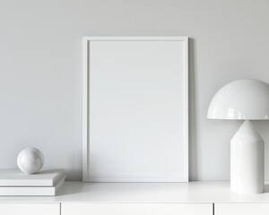 White frame mockup on the chest of drawers near table lamp, b…