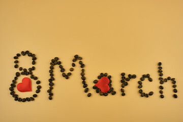 The March 8 inscription is made of coffee beans isolated on a beige background. Copy space, top view. Festive background.
