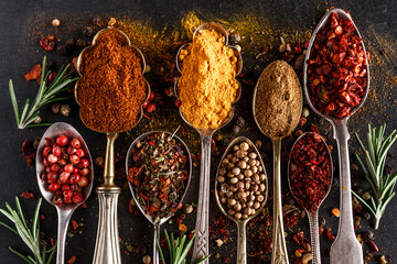 Various spices a vintage spoons on stone table. Colorful Herbal and Spices Oriental marketplace.Top view . Cafe concept. Delicious food delivery.