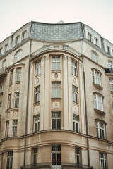 Fototapeta na wymiar Symmetric facade of an old building with beautiful white windows