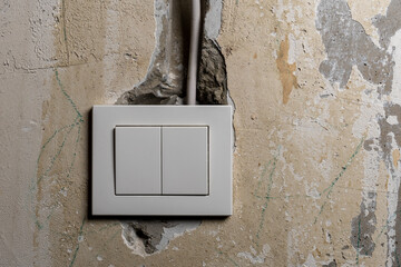 Poorly connected electrical switches on the background of old finishes.