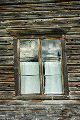 Old skewed and tilted window in an old timber wall