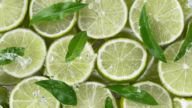 Super slow motion of lime slices with splashing water, top view. Filmed on high speed cinema camera, 1000 fps.