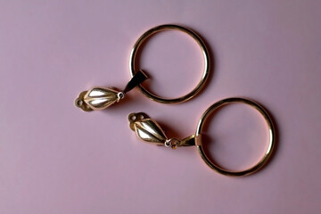 Vintage golden earrings on pink background. Top view. 