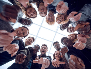 group of diverse young people standing in a circle and pointing at you