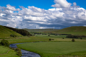 Fototapeta na wymiar landscape with sky and clouds; windmills on hillside