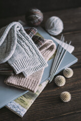 Fototapeta na wymiar Hand knitting socks with needles and yarn balls ion a dark wooden background. Concept for handmade and hygge slow life.