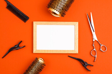 Mockup wooden frame flat lay of professional hair cutting shears, gold round hair brushes for...