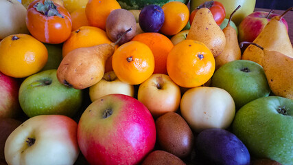 Fruit background. Apples, oranges, pears, persimmons, plums.