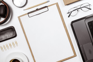 Flat lay of stylish male workplace with clip folder, laptop and business accessories on white background