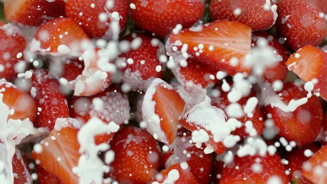 Super slow motion of strawberries with splashing cream, top view. Filmed on high speed cinema camera, 1000 fps.