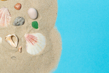 Fototapeta na wymiar Layout with fine sea sand, shells and pebbles on a blue background, horizontally. Close-up, with space