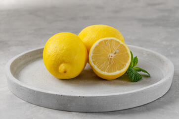 Fresh yellow lemons on a gray concrete background. The color of the year.