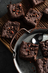 Dark chocolate brownies with choco drops on old metal tray