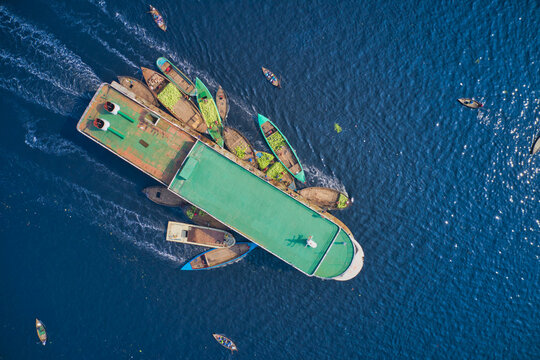 Aerial view of traditional boats sailing along a motor boat used for commercial purposes along Buriganga river in Keraniganj, Dhaka, Bangladesh.