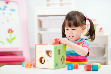 young  girl playing number shape blocks for homeschooling