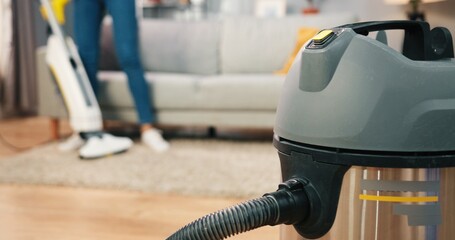 Close up shot of professional vacuum cleaner in apartment room, worker specialist vacuuming carpet...