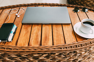 top view of the workspace with a laptop, on a brown wooden table with a smartphone a cup of coffee and a notebook. Remote work. Copy space, wood background