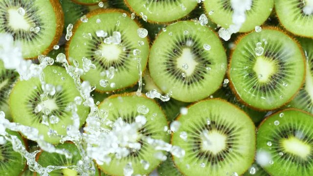 Super slow motion of kiwi slices with splashing water, top view. Filmed on high speed cinema camera, 1000 fps.
