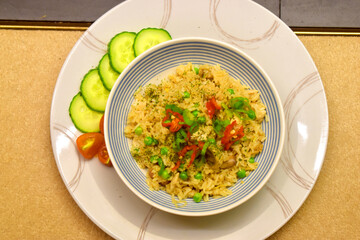 Chicken fried rice with mushroom, green pea. Seasoning with red chilli and side dish with organic fresh cucumber and tomato.