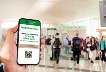 The digital green pass of the european union with the QR code on the screen of a mobile held by a...