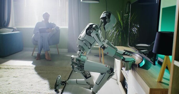 Robotic housekeeper wiping dust near owner