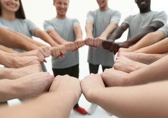 group of young people making a circle out of their hands