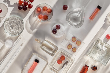 Cosmetic skincare background with red grapes. Abstract white flat lay cosmetic laboratory...