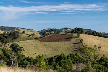 Fototapeta premium Agricultural fields used for plantation and pasture fields for farming cattle on the mountainous landscape of Cunha at the south side of O Contemplario farm.