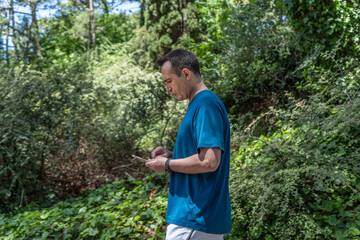 Male athlete using his smartphone while walking outdoors