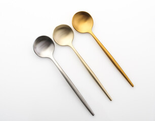 Metal teaspoons on a white background. Gold and silver spoons
