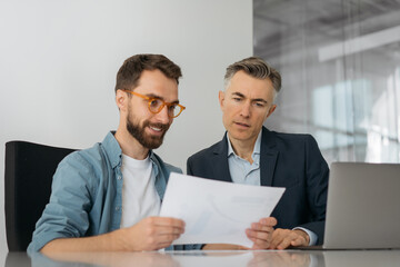 Businesspeople using reading financial report, analyzing statistics, planning start up, working...