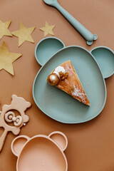 Flat lay minimal Baby birthday concept. Top view composition with newborn accessories, birthday cake, wooden toys on brown background.