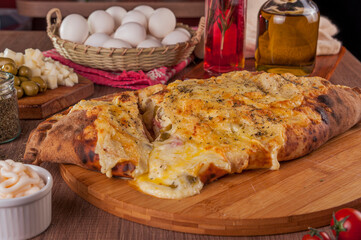 Calzone pizza with ham, cream cheese and heart of palm - Closeup.