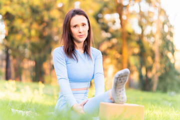 Beautiful young woman doing yoga in a park at sunset in spring or summer. yoga instructor concept. yoga class. commercial yoga. copy space