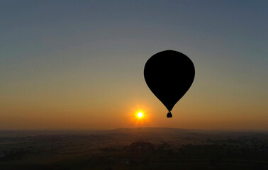 Hot Air Balloons Taking Off at Sunrise at a Hot Air Balloon Festival on a Misty Morning